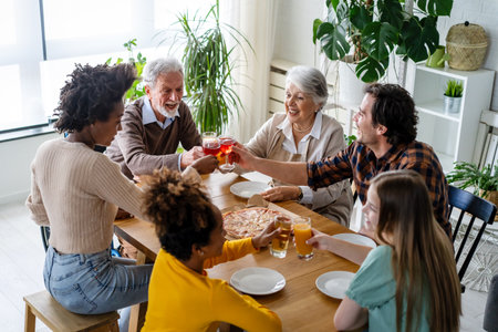 Multiethnic diverse extended family dining and toasting togetherの写真素材