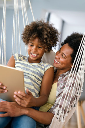 Happy african american single mother helping child with distance education. Online educationの写真素材