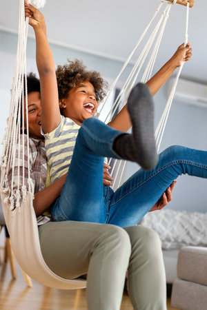 Family concept. Happy african american mother and daughter spendig fun time together at homeの写真素材