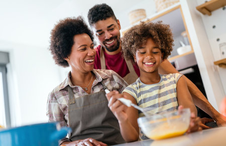 Overjoyed young african american family with kid have fun cooking at home together,の写真素材