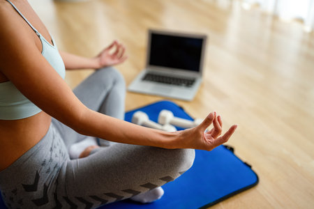 Happy fit sporty woman exercising to stay healthy. Fitness workout at home, watching videos onlineの写真素材