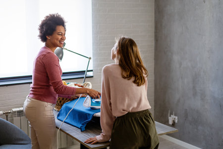 Happy child helping african american mother do household and domestic chores togetherの写真素材