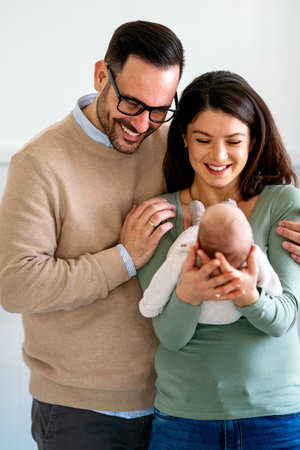 Family, adoption, baby, parenthood and people concept. Happy mother father with newborn baby at homeの写真素材