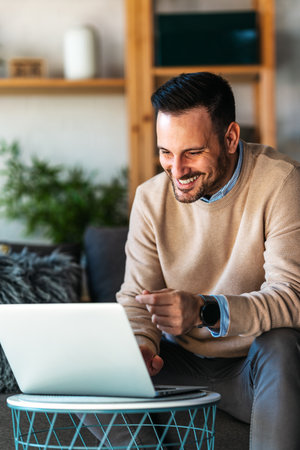 Technology remote job and lifestyle concept. Success man with laptop computer working at home officeの写真素材