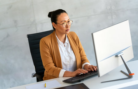 Smiling successful female professional executive hr manager using computer in corporate officeの写真素材