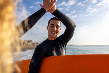 Young beautiful couple of friends on the sea with surfboards in their hands, sports active lifestyleの写真素材