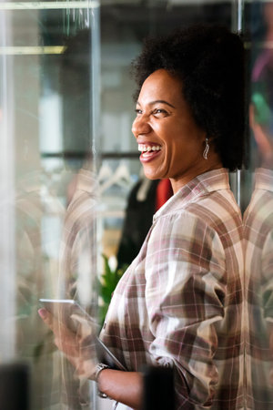 Success black happy business woman using tablet computer and working. Designer manager in her officeの写真素材