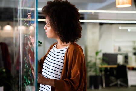 Portrait of african american female IT developer, programmer, designer working with programming codeの写真素材