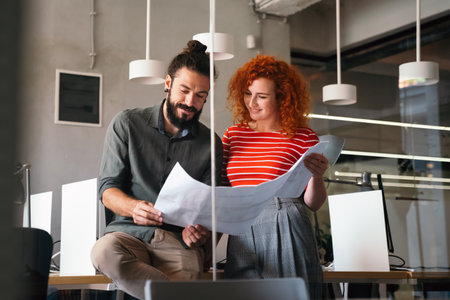 Happy businesspeople laughing while collaborating on a new project in an office. Business startup.の写真素材