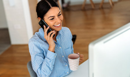 Beautiful young concentrated business woman wearing shirt using laptop in modern workspaceの写真素材