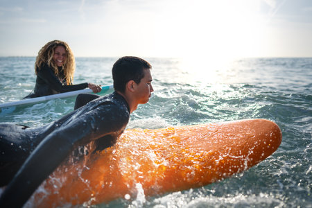 Young couple of friends on the ocean with surfboards in their hand sports active lifestyleの写真素材