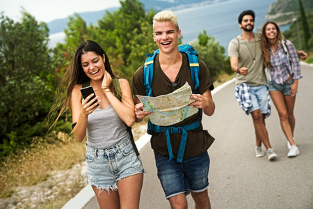 Friendship, travel, vacation, summer and people concept. Group of smiling friends with map travelingの写真素材