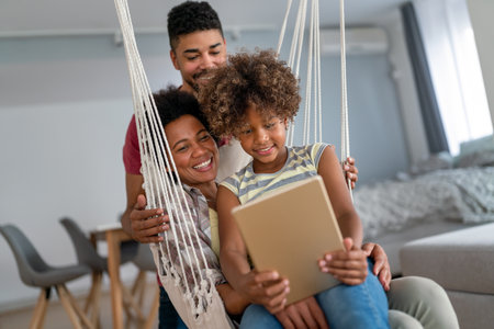 Happy african family having fun with device at home, black parents and child using digital tabletの写真素材