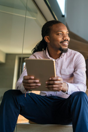Successful African American businessman reading business graphs and stock charts on digital tabletの写真素材