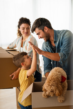 Happy family with child moving with boxes in a new apartment house.の写真素材