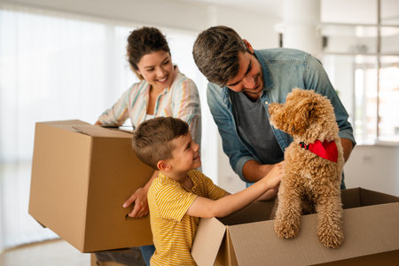 Happy family with cardboard boxes in new house at moving day.の写真素材