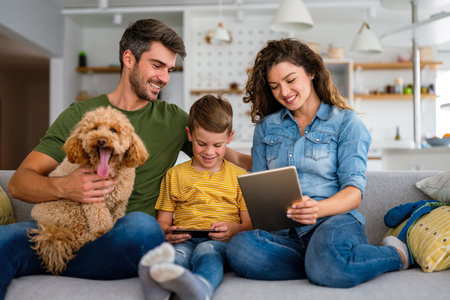 Parents with kid having fun online with application watching video cartoon or playing game on tabletの写真素材