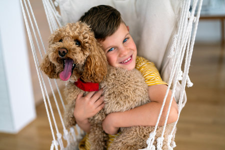 Happy boy hugs his new pet friend, adopted little dog. Human animal friendship. People pet happinessの写真素材