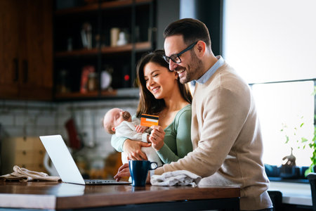 Parents with infant child having video call on laptop at home. Family happiness technology concept.の写真素材