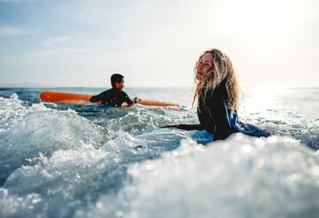 Young beautiful couple of friends on the sea with surfboards in their hands, sports active lifestyleの写真素材