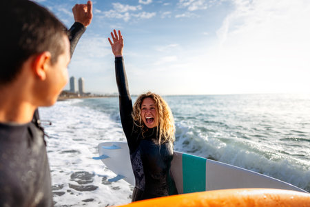 Young beautiful couple of friends on the ocean with surfboards in their hand sports active lifestyleの写真素材