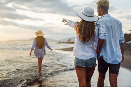 Young couple walking in the sea while smiling and enjoying summer vacation, travel togetherの写真素材