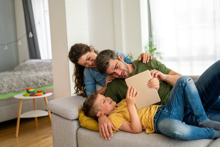 Happy family, parents with cute excited small kids son using tablet computer at home. Technologyの写真素材