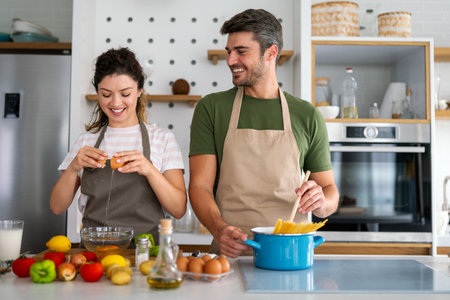 Happy couple enjoying cooking in the kitchen feeling happy and carefree on weekend lifestyle at homeの写真素材