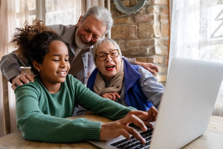 Portrait of a happy multigeneration family using electronic devices at home togetherの写真素材