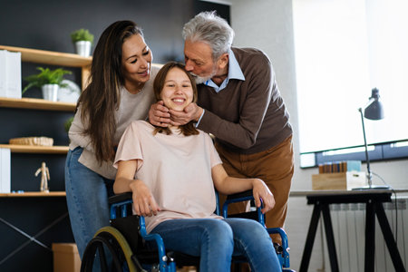 Happy multiethnic family with child with disability in wheelchairの写真素材