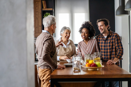 Multi generation multiethnic family having fun, talking around a kitchen table.の写真素材
