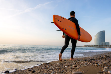 Happy young fit man with surfing board at beach, sea and ocean for summer. Travel adventure or hobbyの写真素材