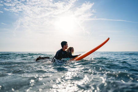 Two friends surfers going for surfing in the sea. Carrying surfboards running in to the sea surfing
