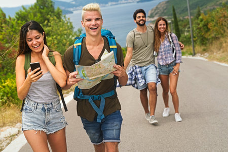 Happy friends on a road trip have fun, piggybacking at the roadside and enjoying summer vacationの写真素材