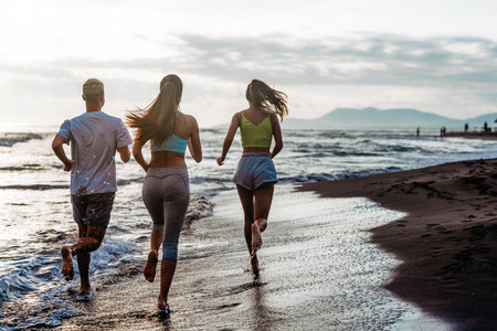 Group running on beach jogging having fun training. Exercising runners training outdoorsの写真素材