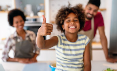 Overjoyed young african american family with kid have fun cooking at home together,の写真素材