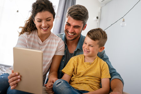 Happy family, parents with cute excited small kids son using laptop computer at home.の写真素材