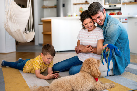 Mother, father and kid with dog in living room for quality time, love and care together on weekendの写真素材
