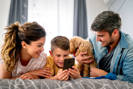Happy family parents and kid use laptop phone digital tablet at homeの写真素材