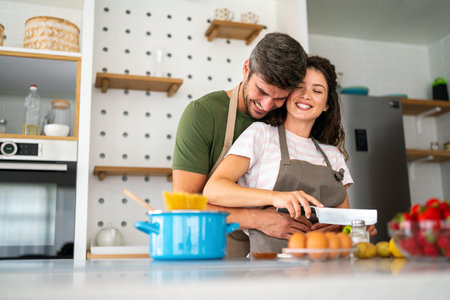 Young happy couple is preparing healthy meal in their kitchen together at home. Healthy lifestyleの写真素材