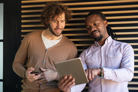 Two business people working together using digital tablet pc and talking about a business project.の写真素材