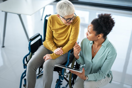 The image includes a person using a wheelchair, depicting inclusivity and teamwork in modern officeの写真素材
