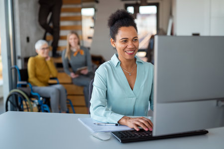 Business woman working on laptop computer reading financial document report in officeの写真素材