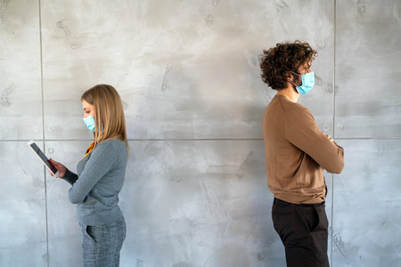 Social isolation at work, university. Young business people face masks in the office trying to workの写真素材