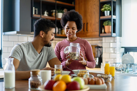 Happy african american couple having breakfast together in the kitchenの写真素材