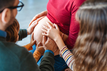 Loving young family, children and pregnant woman holding hands on belly, waiting for baby,pregnancy