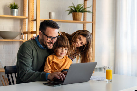 Happy parent with cute excited small kid son using laptop computer at home. Technologyの写真素材