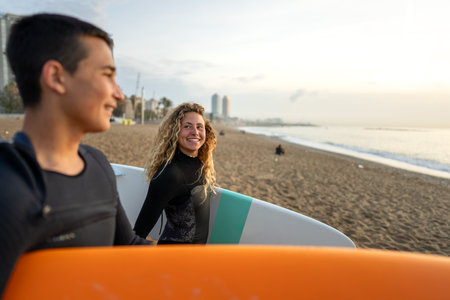 Two friends surfers going for surfing in the sea. Carrying surfboards running in to the sea surfingの写真素材