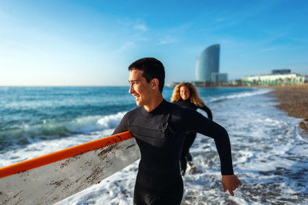 Young people having fun, enjoying their vacations outdoors at the beach with surfboardsの写真素材