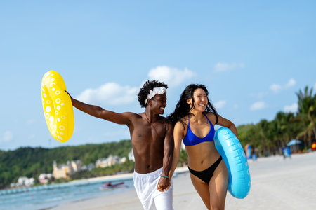Interracial couple enjoying a romantic beach getaway, embracing love, laughter, and togethernessの写真素材